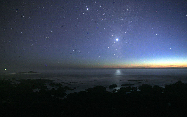 Venus as a bright star low in the early evening sky above the ocean